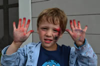 Kid's hands with red chalk dust